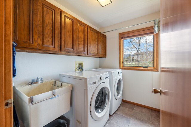 6280 Alamosa Ln, Bozeman, MT 59718 - laundry area featuring a sink, cabinet space, separate washer and dryer, light tile patterned floors, and baseboards