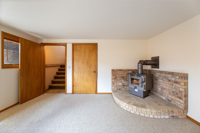 6280 Alamosa Ln, Bozeman, MT 59718 - below grade area featuring carpet flooring, stairway, a wood stove, and baseboards