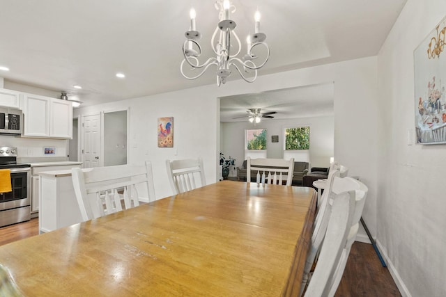 dining space with baseboards, ceiling fan with notable chandelier, recessed lighting, and wood finished floors