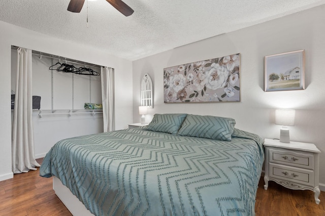 bedroom featuring a textured ceiling, baseboards, wood finished floors, and a ceiling fan