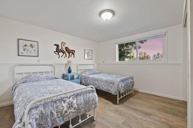 bedroom with wood finished floors and baseboards