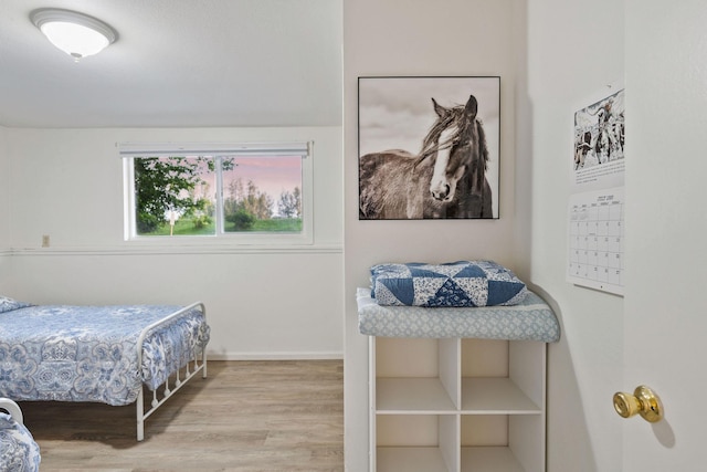 bedroom with baseboards and wood finished floors