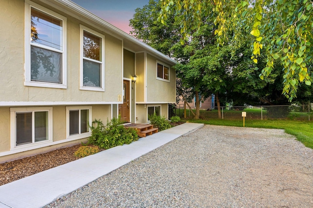 exterior space with stucco siding and fence