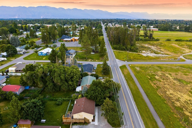 aerial view at dusk featuring a mountain view and a residential view