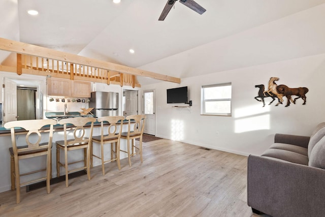 living area featuring light wood-style flooring, a ceiling fan, baseboards, vaulted ceiling, and recessed lighting