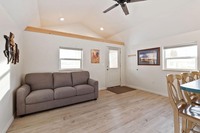 living area with a ceiling fan, light wood-style floors, baseboards, and vaulted ceiling