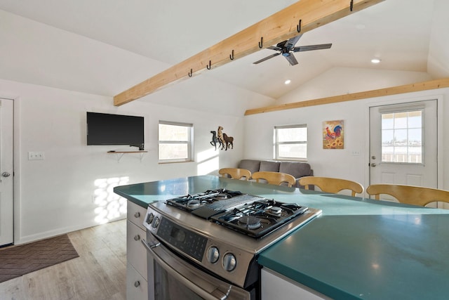 kitchen featuring a ceiling fan, stainless steel gas range oven, recessed lighting, lofted ceiling with beams, and light wood-type flooring