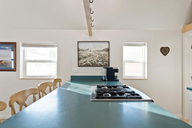 dining space with beam ceiling and plenty of natural light