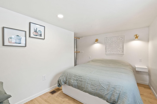 bedroom with visible vents, wood finished floors, baseboards, and recessed lighting