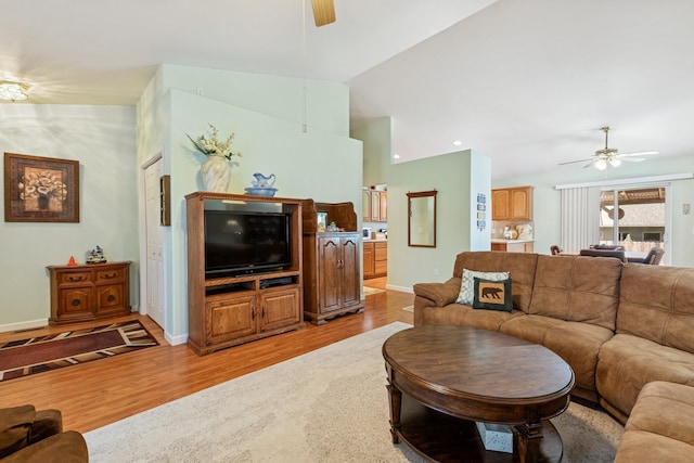 living area with baseboards, light wood finished floors, and ceiling fan