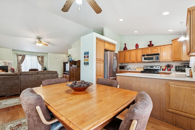 dining area with light wood-style floors, vaulted ceiling, a toaster, and ceiling fan