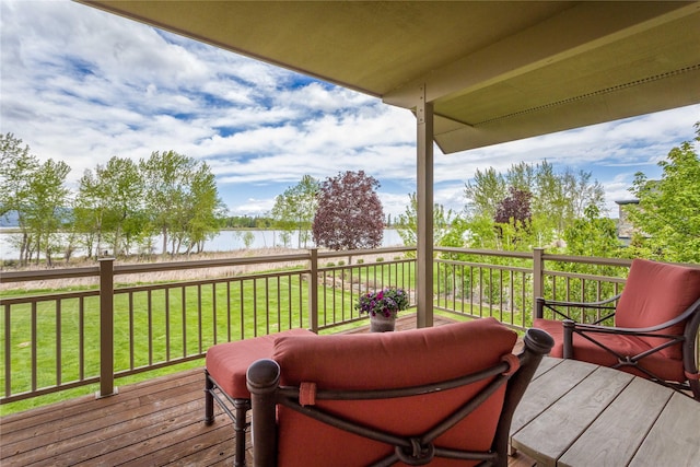 wooden deck featuring a water view and a lawn
