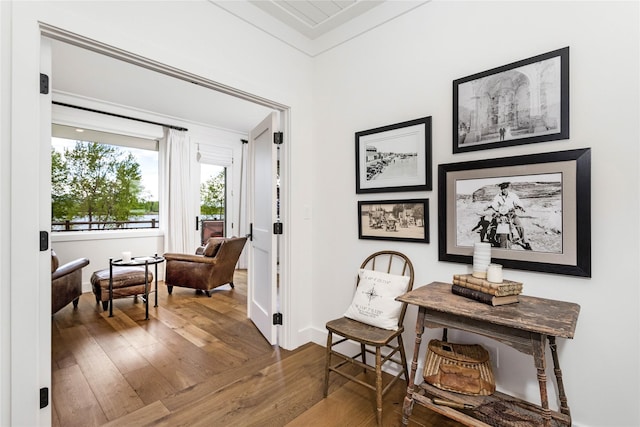 living area featuring baseboards and hardwood / wood-style flooring