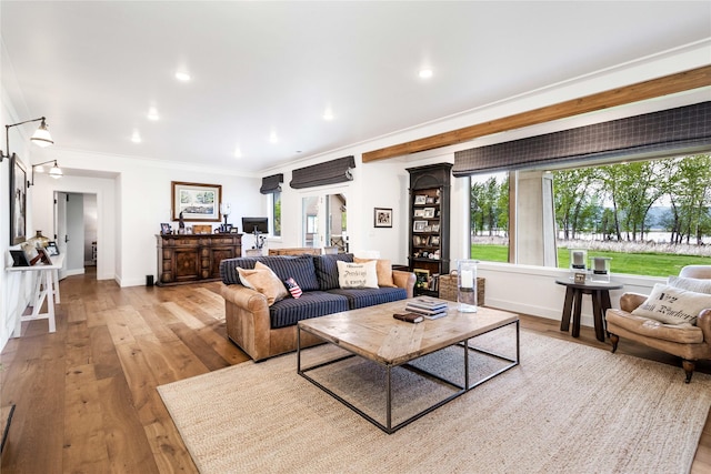 living area with light wood finished floors, ornamental molding, baseboards, and recessed lighting