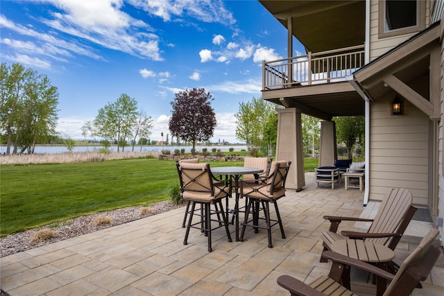 view of patio / terrace with outdoor dining area, a water view, and a balcony