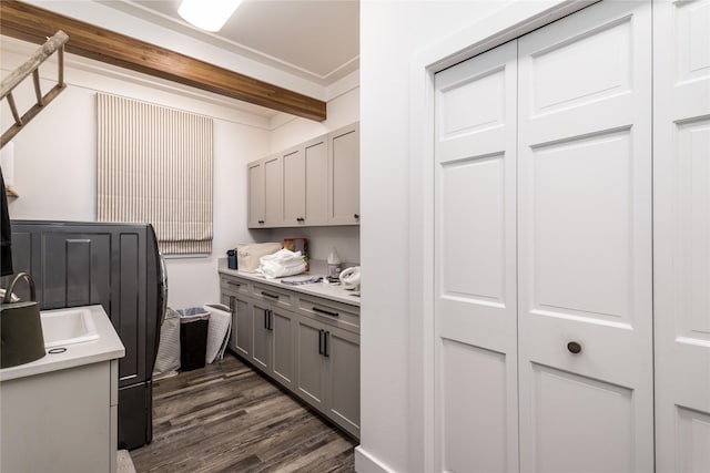 kitchen featuring light countertops, gray cabinets, dark wood-style flooring, and a sink