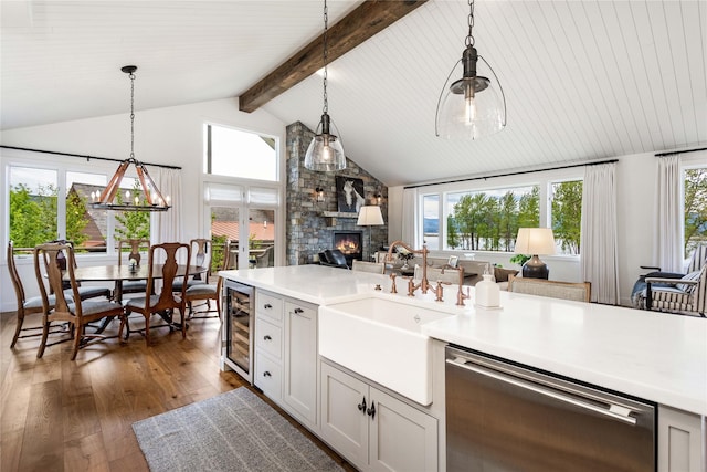 kitchen featuring wine cooler, dishwasher, dark wood-style flooring, a sink, and open floor plan