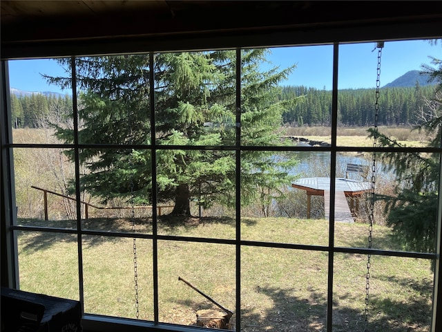 interior space featuring a water view and a view of trees
