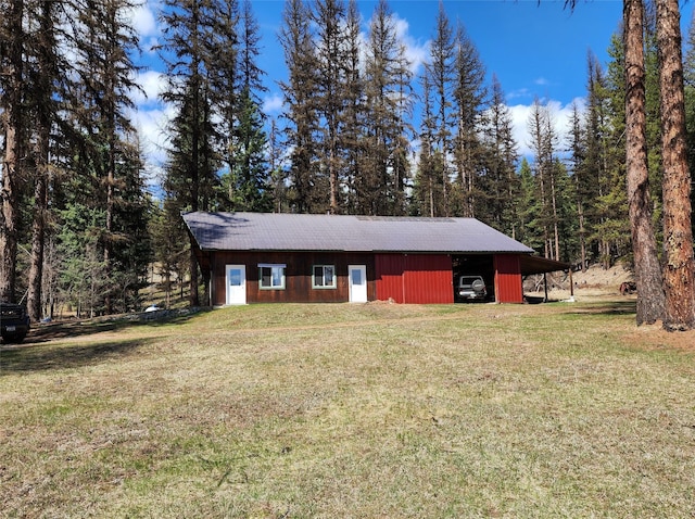view of pole building with a yard and a forest view
