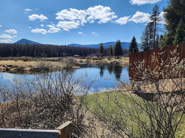 water view with a mountain view and fence
