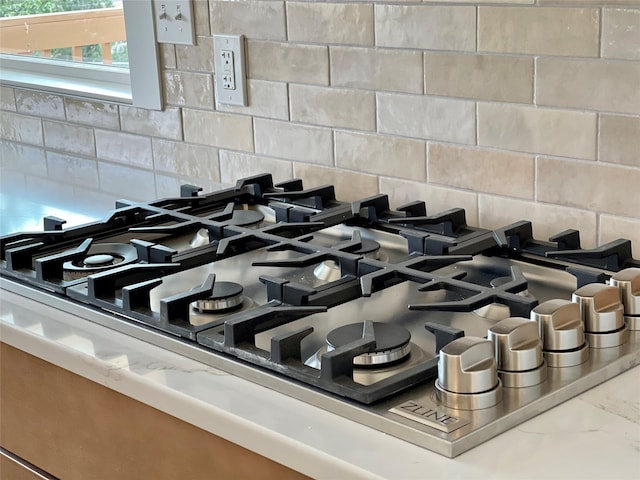 room details with stainless steel gas stovetop and decorative backsplash