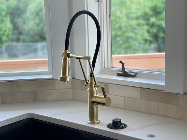 details with light stone counters, a sink, and decorative backsplash
