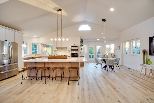 kitchen featuring light countertops, stainless steel appliances, white cabinets, and a kitchen island