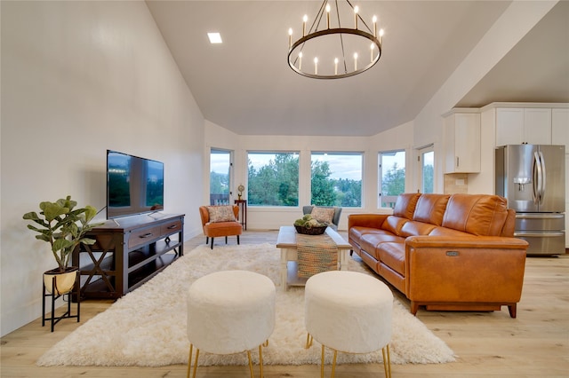 living room with baseboards, light wood finished floors, a chandelier, and high vaulted ceiling