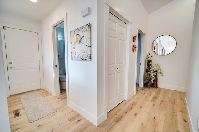 entryway featuring baseboards, light wood-type flooring, and visible vents