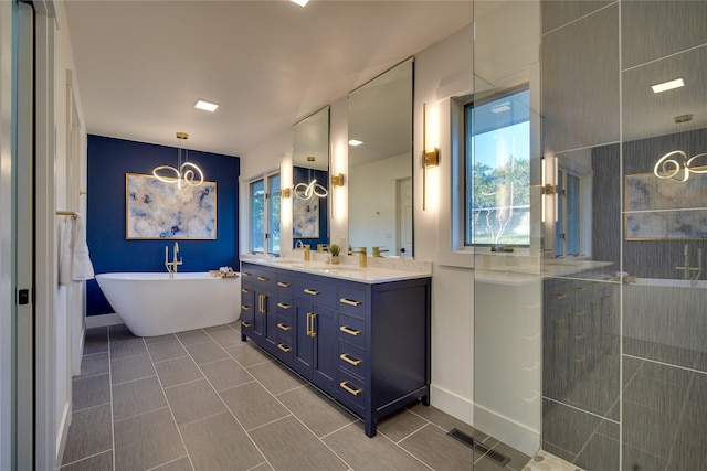 bathroom with visible vents, tile patterned floors, a walk in shower, double vanity, and a freestanding tub