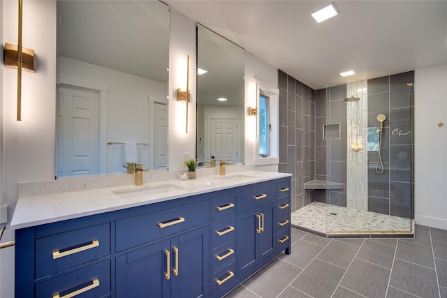 bathroom featuring tile patterned flooring, walk in shower, double vanity, and a sink