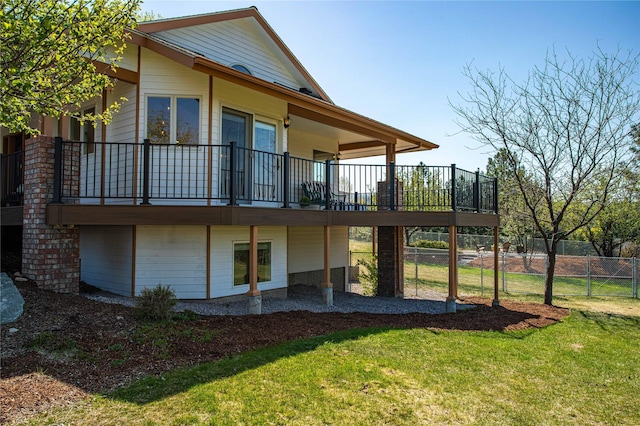 back of property with a yard, fence, and a deck