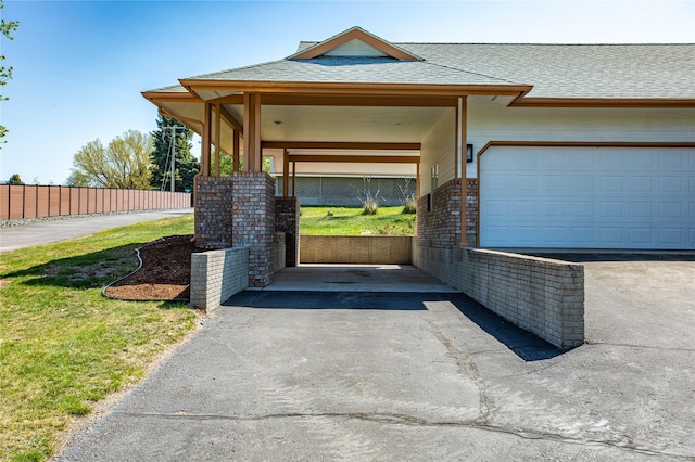 exterior space featuring aphalt driveway, fence, and an attached garage