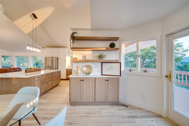 kitchen featuring open shelves, light wood-type flooring, stainless steel fridge, hanging light fixtures, and baseboards