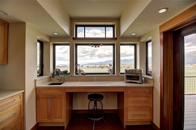 office area featuring a sink, dark wood-style flooring, baseboards, a textured wall, and recessed lighting
