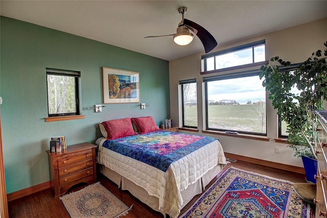 bedroom featuring wood finished floors, baseboards, and ceiling fan
