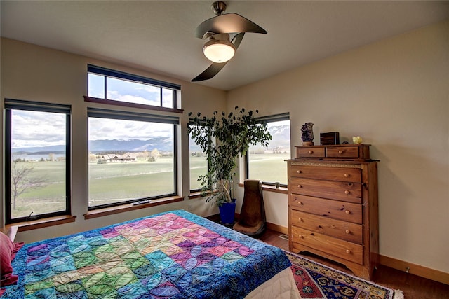 bedroom with wood finished floors, baseboards, and ceiling fan