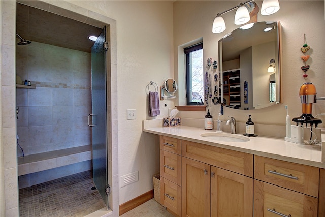 bathroom with vanity, baseboards, and a shower stall