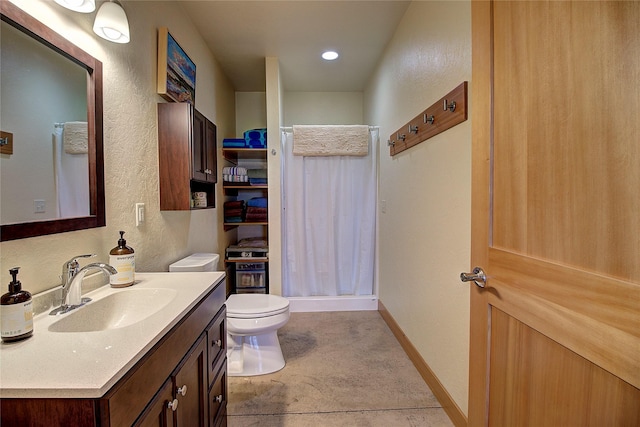 full bath with baseboards, toilet, a shower stall, vanity, and a textured wall