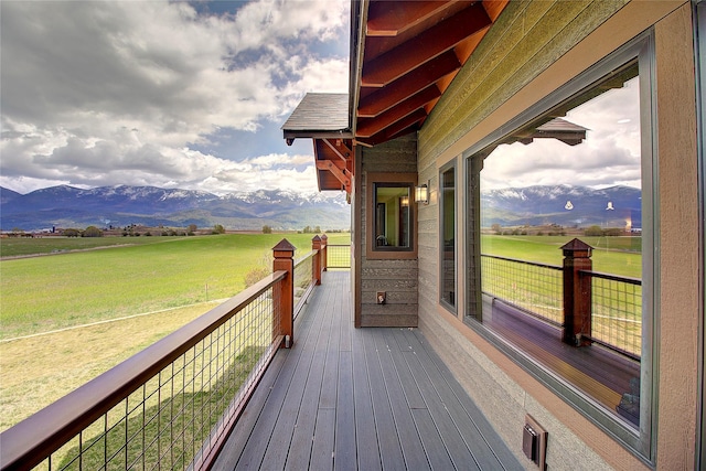 wooden terrace with a rural view and a mountain view