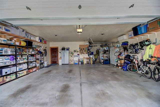 garage with freestanding refrigerator and a garage door opener