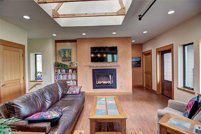 living room featuring baseboards, recessed lighting, a large fireplace, and wood finished floors