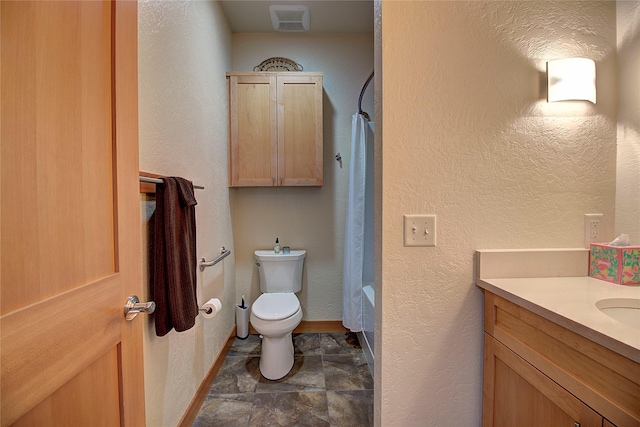 full bathroom featuring toilet and a textured wall