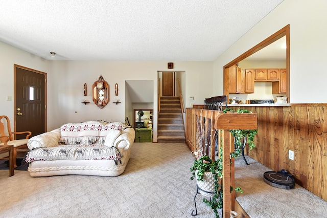 living area featuring stairway, a textured ceiling, and carpet