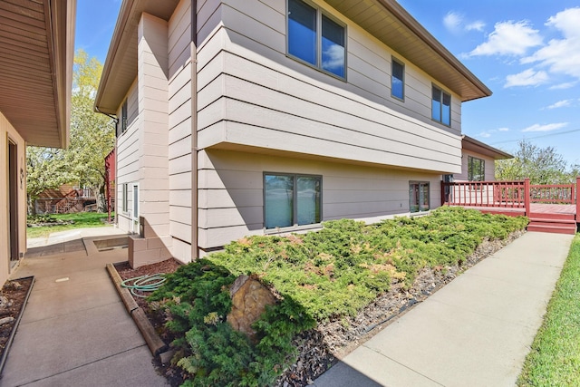 view of property exterior with a wooden deck