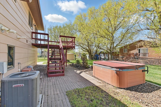 view of patio / terrace featuring central air condition unit, a hot tub, a wooden deck, and stairs
