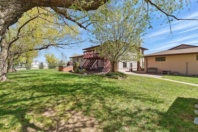 view of yard with a deck, stairway, a hot tub, and a patio area