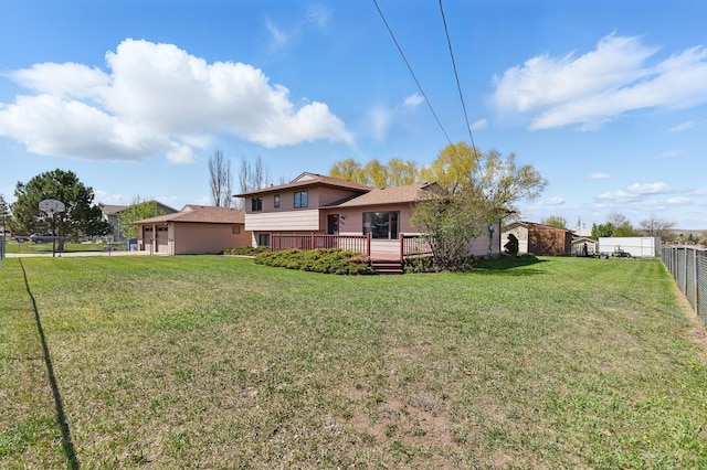 back of house with a yard, fence, and a deck
