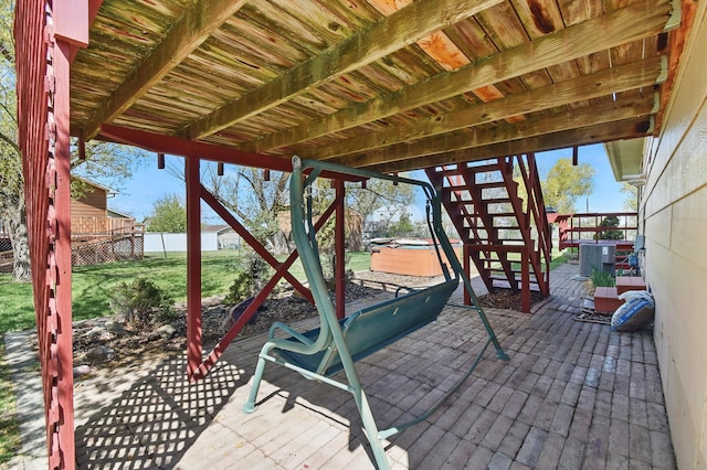 view of patio / terrace featuring a hot tub, fence, a wooden deck, and central air condition unit