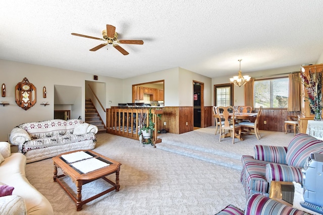 living room with light colored carpet, a wainscoted wall, and a textured ceiling